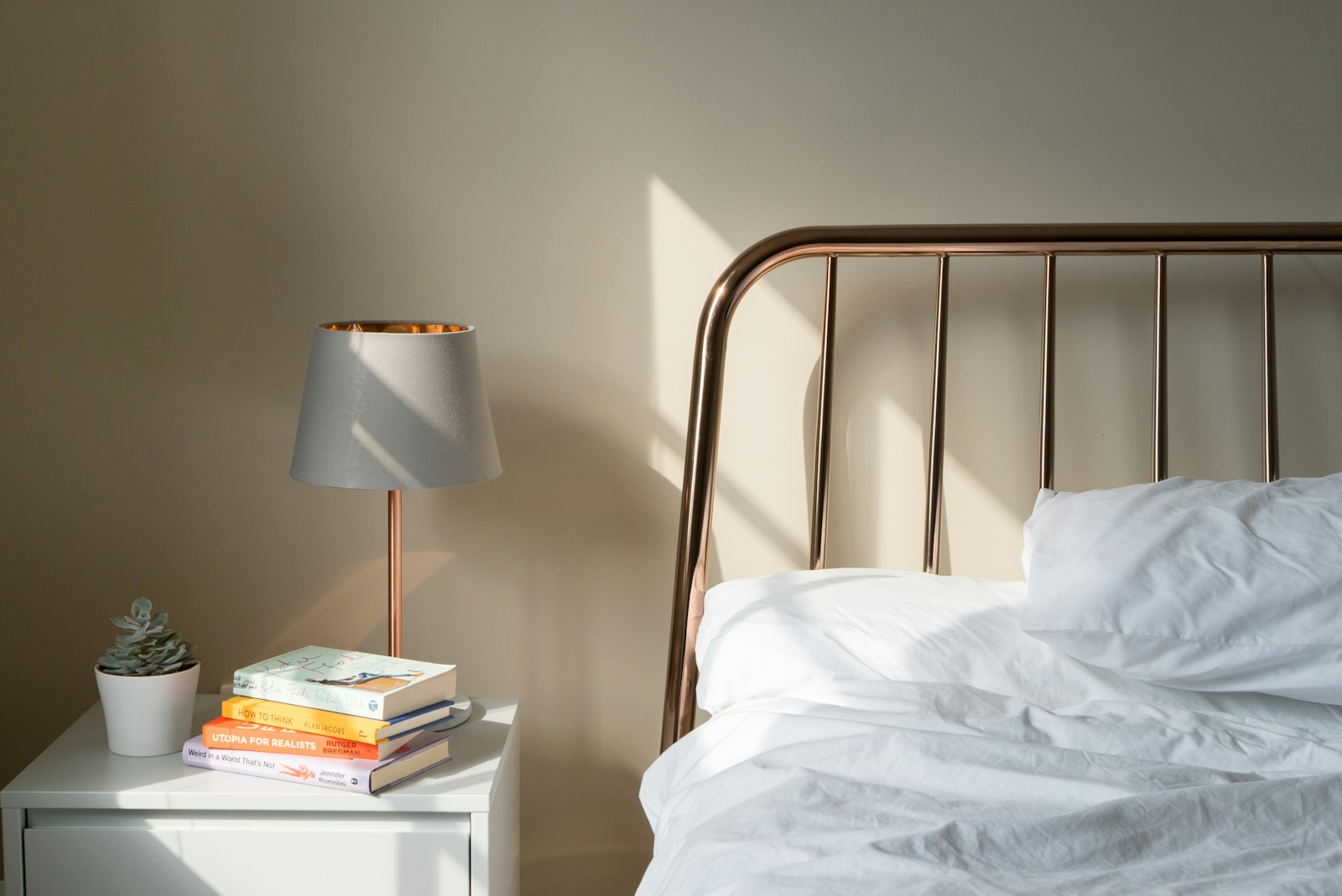 Table lamp on a white wooden nightstand beside a bed