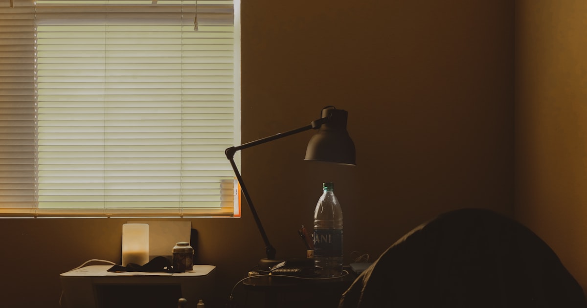 A black desk lamp on a wooden desk