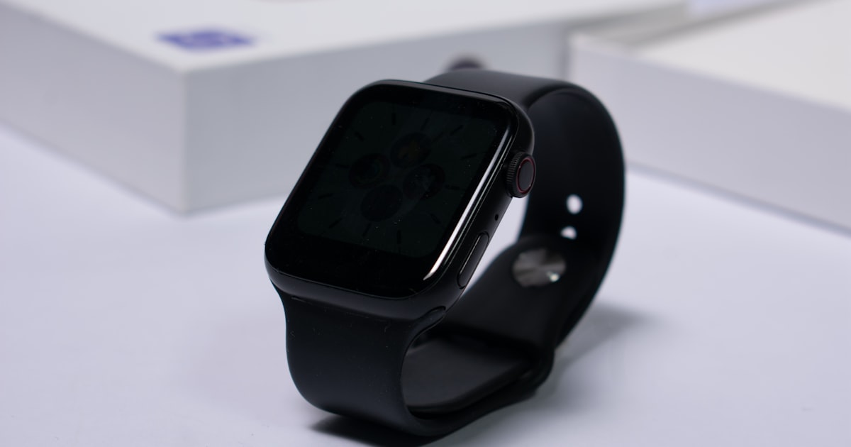 A smartwatch with a white sport band worn on a wrist