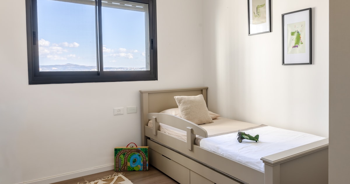 A child's bedroom with a twin bed and toys